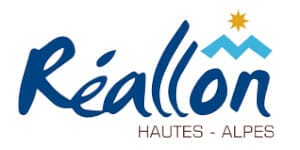 Logo of Réallon Hautes-Alpes featuring stylized blue text "Réallon" with a mountain icon and a sun on top. The text "HAUTES-ALPES" is written below.